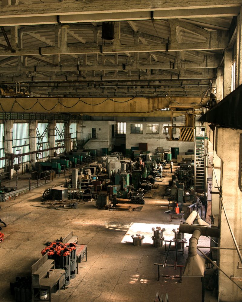 old factory hall with equipment and machines and workers